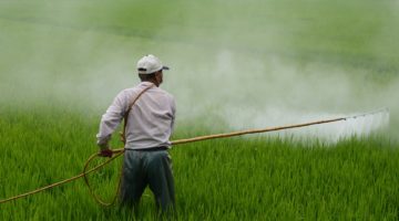 farmer applying pesticides to field