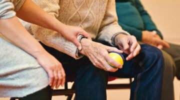 Elder man in nursing home holding a ball