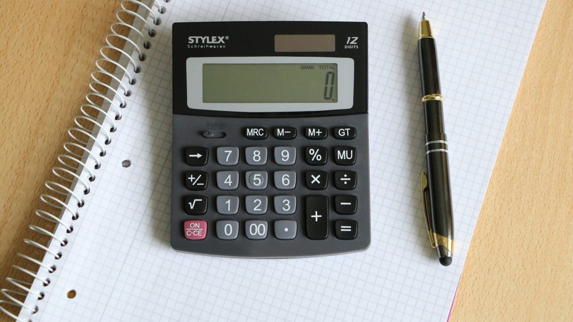 A calculator and pen on a notepad