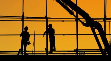 construction workers at twilight with crane in background