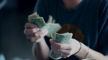 woman counting out us dollar bills