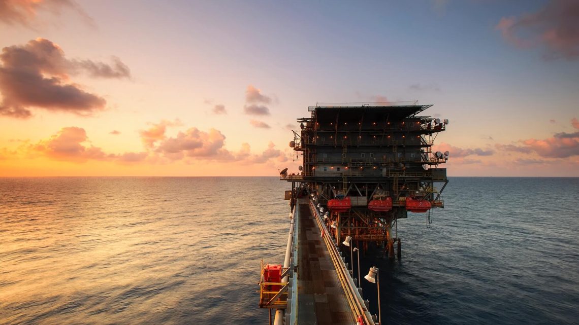 An open-ocean oilfield visible during the sunrise