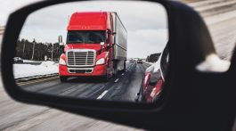 Semi-truck in side view mirror