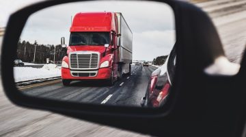 Semi-truck in side view mirror