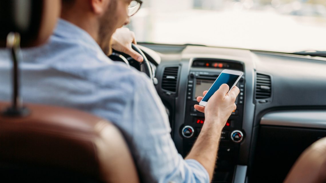 Man distracted on phone while driving.