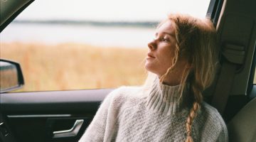 woman sitting in car looking out of the window