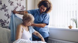 nurse putting blanket on patient