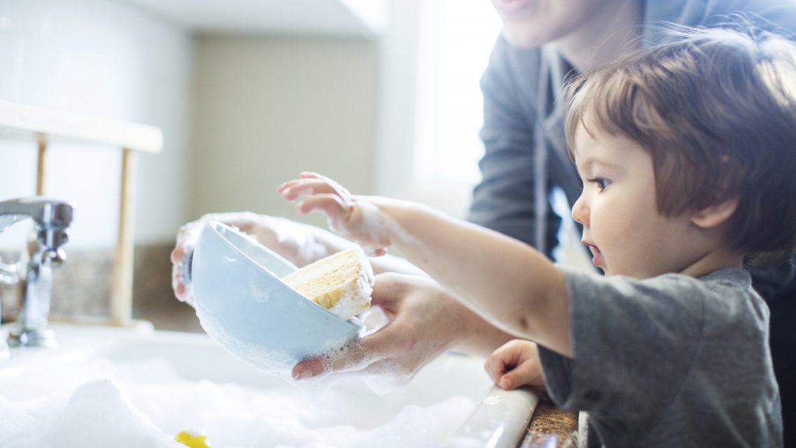 Small child washing dishes.