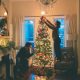 two individuals decorating a Christmas tree