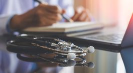 stethoscope on table with a doctor in the background