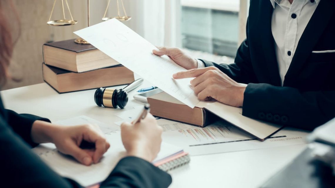 Attorney reviewing a legal document or contract during a consultation for a business dispute.