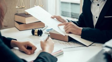 Attorney reviewing a legal document or contract during a consultation for a business dispute.